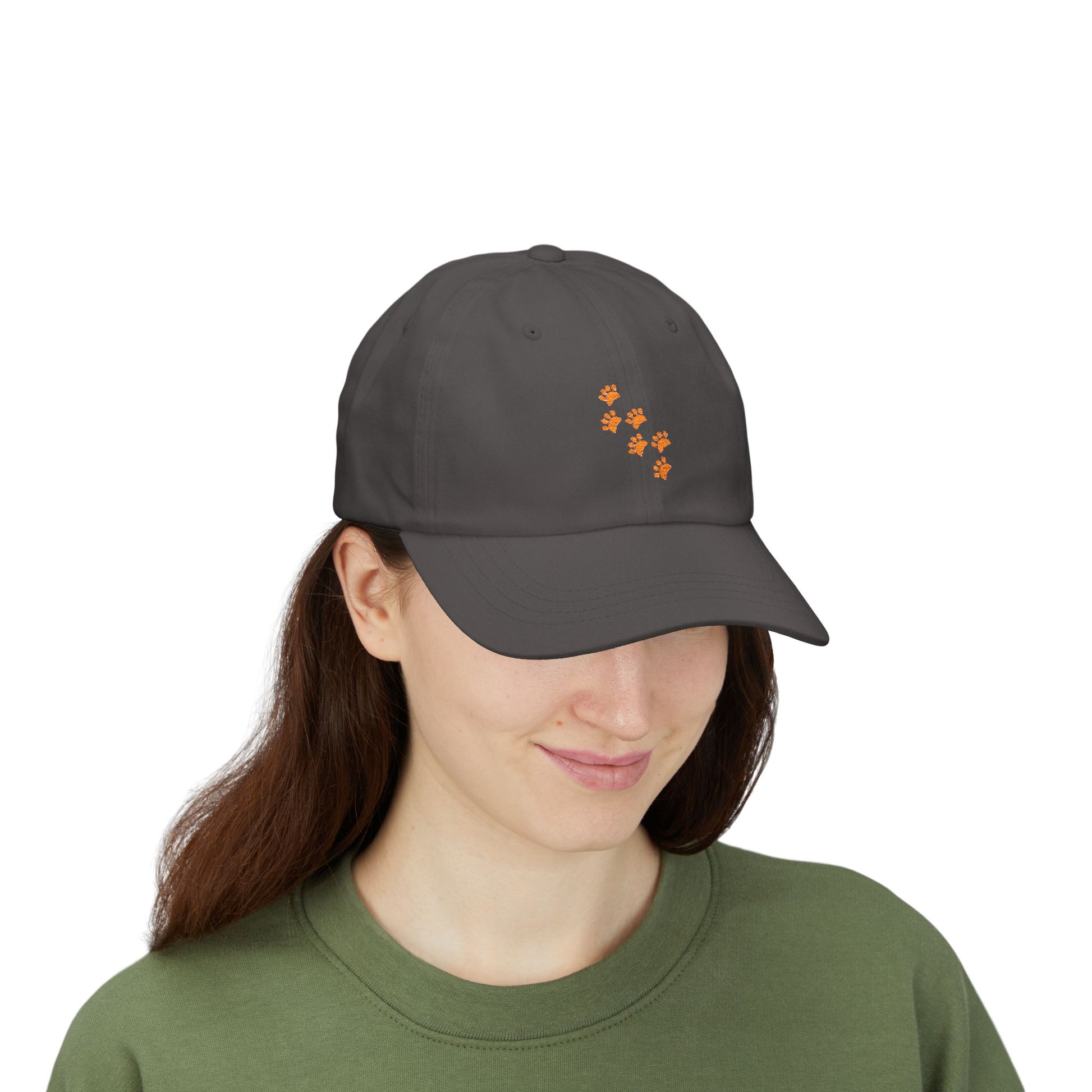 It is a baseball hat with paw prints on it and a girls wears the hat. 